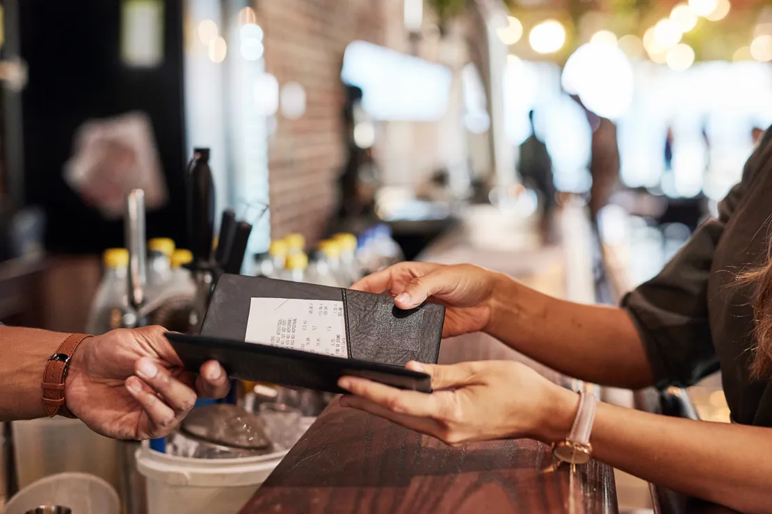 Woman Being Handed A Bill In A Bar