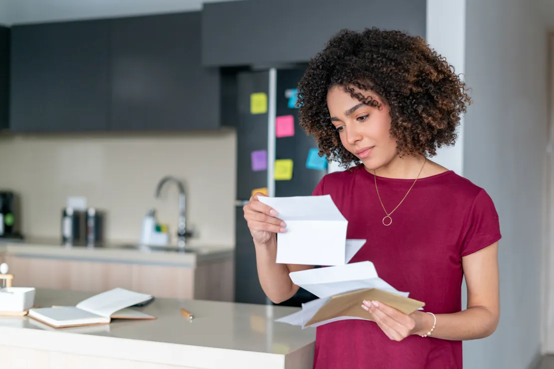 Woman Opening Envelope Containing Documents