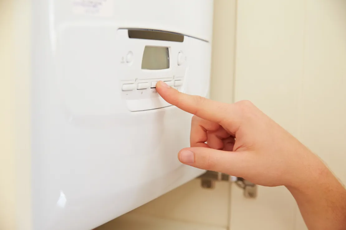 Close Up Of A Person Using The Controls On A Home Boiler
