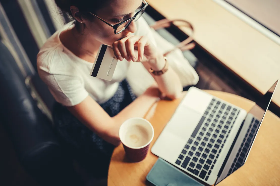 Woman Looking Concerned With Credit Card In Hand