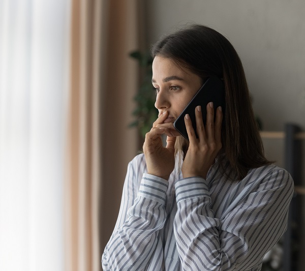 Woman Answering The Phone Looking Concerned
