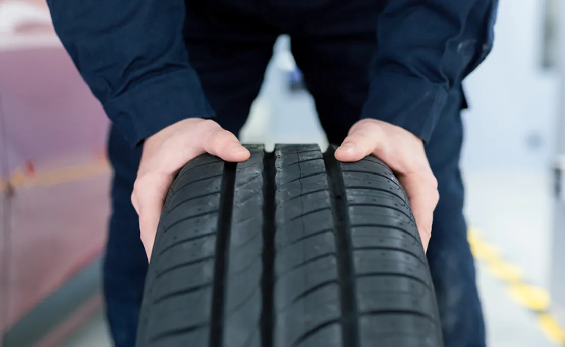 Close Up Of A Mechanic Holding A Car Tyre